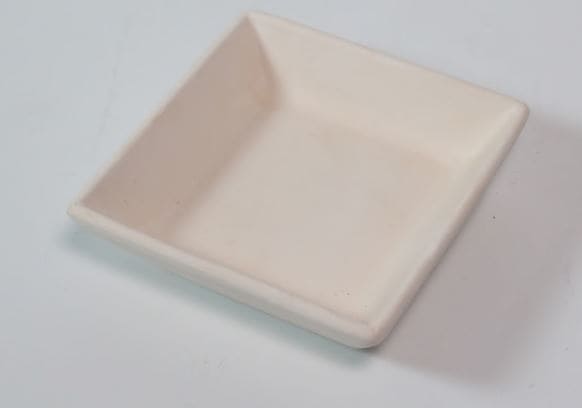 Plato pequeño cuadrado de cerámica biselada, ideal para servir pan o aperitivos.