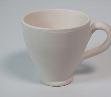 Taza de cerámica hecha a mano con forma abombada.