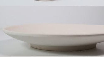 Detalle del borde fino y superficie mate del plato de pan de cerámica personalizable.