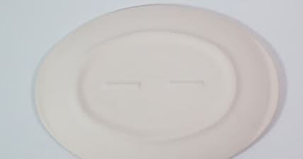 Detalle del reverso acabado mate de la bandeja ovalada de cerámica, en tono marfil claro, lista para personalizar.