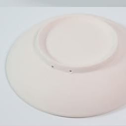 Detalle del reverso y de la forma ligeramente profunda de la bandeja redonda de cerámica artesanal.
